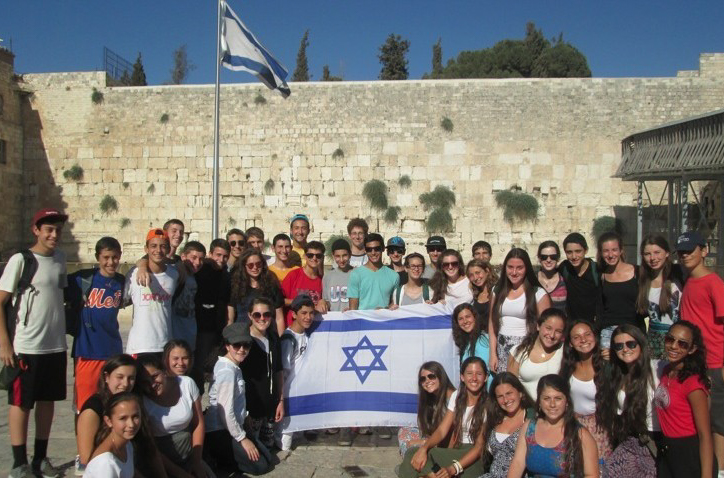 A group of campers holding the Israeli flag.