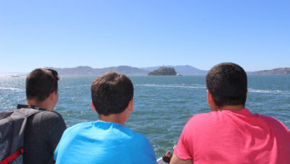 Three campers looking at an ocean view.