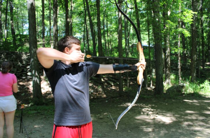 A camper practicing archery.