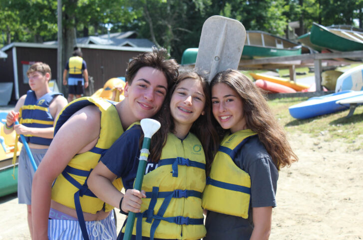 Three campers wearing life jackets.
